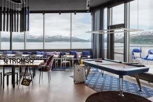 a room with tables and a pool table at Moxy Tromso in Tromsø