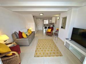 a living room with a couch and a flat screen tv at Parque Santiago 1 F-348 by TENERIFE DREAM PROPERTIES in Playa de las Americas