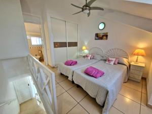 sypialnia z 2 łóżkami i różowymi poduszkami w obiekcie Parque Santiago 1 F-348 by TENERIFE DREAM PROPERTIES w Playa de las Americas