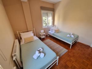 2 łóżka w małym pokoju z ręcznikami w obiekcie Sunny View w mieście Iraklitsa