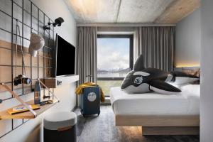 1 dormitorio con cama y ventana grande en Moxy Tromso, en Tromsø