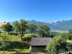 un granero en un campo con montañas en el fondo en Haus Sonnenblick en Düns