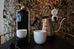 a coffee maker and two cups on a table at Hotel MOTTO in Vienna
