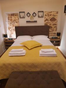 a bedroom with a bed with two towels on it at Harmony 2 in Gold in Lávrion