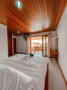 um quarto com duas camas e um teto de madeira em Arbiru Beach Resort em Dili