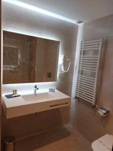 La salle de bains est pourvue d'un lavabo et d'un miroir. dans l'établissement Hotel Saurat, à Espot