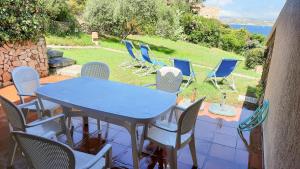 a table and chairs on a patio with a view of the ocean at Welcomely - Porto Rafael Apartments in Palau