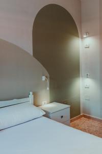 ein Schlafzimmer mit einem weißen Bett mit einem Bogen darüber in der Unterkunft Bed Station Hostel & Bar in Shkodra