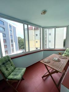 a balcony with a table and chairs and windows at Chaika Sea Apartment in Varna City