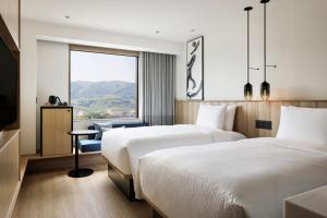 a hotel room with two beds and a window at Fairfield by Marriott Hyogo Awaji Higashiura in Awaji