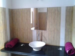 a bathroom with a black counter with a white bowl at Starco in Anjuna