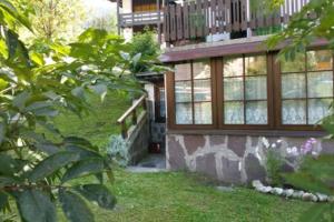 a house with a balcony and a yard at Cozy Alpine House di Svaizer in San Martino di Castrozza