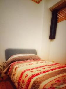 a bedroom with a bed with a red and white blanket at Cozy Alpine House di Svaizer in San Martino di Castrozza