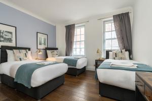 - une chambre avec 2 lits et 2 fenêtres dans l'établissement Marble Arch Apartments, à Londres