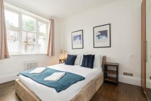 - une chambre avec un grand lit et une couverture bleue dans l'établissement Marble Arch Apartments, à Londres