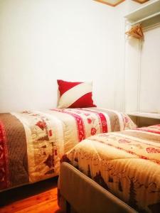 two beds sitting next to each other in a room at Cozy Alpine House di Svaizer in San Martino di Castrozza