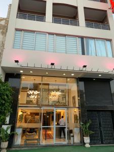 a large white building with a man walking into it at Hôtel Belle Vue et Spa in Meknès