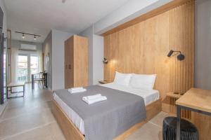 a bedroom with a large bed with a wooden wall at Unique Aura Luxury Studios in Neos Marmaras