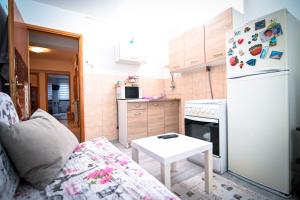 a small kitchen with a white refrigerator and a table at Marko Polo Apartment in Sarajevo