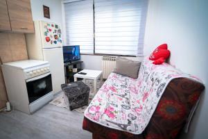 a small living room with a couch and a refrigerator at Marko Polo Apartment in Sarajevo