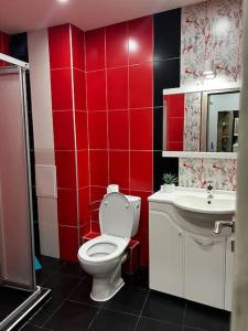 a red bathroom with a toilet and a sink at Blue & Gold Stylish Apartment in Sofia