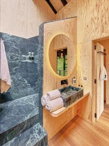 ein Bad mit einer Dusche, einem Waschbecken und einem Spiegel in der Unterkunft Hutstuf The Beaver & Private Outdoor Spa in La-Roche-en-Ardenne