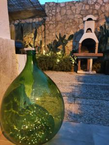 un vaso di vetro verde seduto di fronte a un edificio di DIMORA ARTEMISIO a Siponto