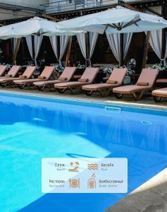a swimming pool with chairs and umbrellas next to it at Hotel Otrada in Odesa