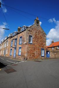 an old brick building on the side of a street at Auld Fishers Hoist- traditional home by the sea in Anstruther