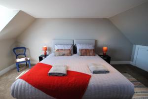 a bedroom with a large bed with a red blanket at Auld Fishers Hoist- traditional home by the sea in Anstruther