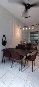 S99 HOMESTAY KUDAT في كودات: غرفة طعام مع طاولة وكراسي ومطبخ