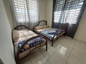 a small room with two beds and two windows at S99 HOMESTAY KUDAT in Kudat