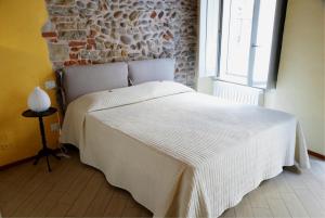 a white bed in a room with a brick wall at B&B Home Sweet Home in Bergamo