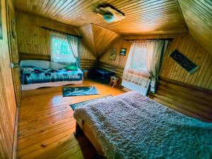 1 dormitorio con 2 camas en una habitación de madera en Private House Затишок, en Zhdeniievo