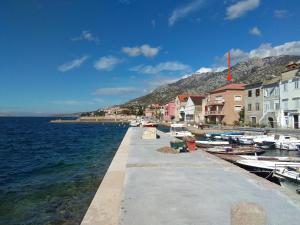 a walkway next to a body of water with boats at Apartments Grkinić in Karlobag