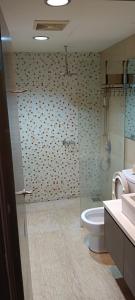 een badkamer met een toilet en een glazen douche bij Regalia Suites in Kuala Lumpur