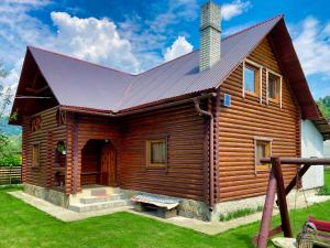 einem Blockhaus mit Metalldach in der Unterkunft Private House Затишок in Schdenijewo