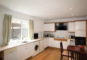 a kitchen with white cabinets and a sink at Whitley Bay - Sleeps 6 - Refurbished Throughout - Fast Wifi - Dogs Welcome in Whitley Bay