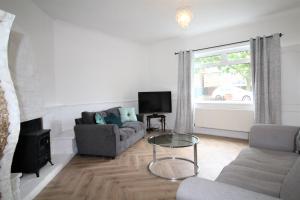 a living room with a couch and a tv at Whitley Bay - Sleeps 6 - Refurbished Throughout - Fast Wifi - Dogs Welcome in Whitley Bay