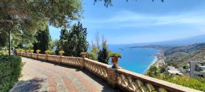 a fence with potted plants on it next to the ocean at Taormina al mare Villetta in Mazzeo
