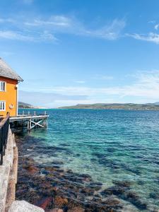 a large body of water with a house and a dock at Sandtorgholmen Hotel - Best Western Signature Collection in Harstad