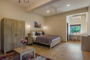 a bedroom with a bed and a table with flowers on it at StayVista at Mawi Summers in Arambol