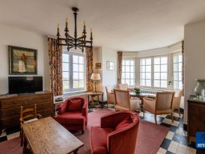 sala de estar con sillas rojas y mesa en Beautiful Normandy villa in an exclusive location, en De Haan