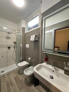 bagno con lavandino, servizi igienici e specchio di Hotel Bogart a Milano