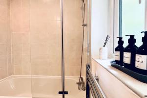 a shower with bottles on a shelf in a bathroom at Urban Bliss Stylish Townhouse with Free Parking for a Convenient City Stay in Liverpool