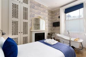 a bedroom with a bed and a sink and a fireplace at Bower House in London