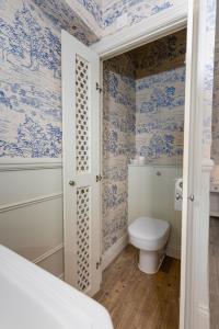 a bathroom with blue and white wallpaper and a toilet at Bower House in London