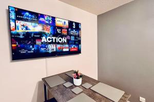 a room with a table with a tv on the wall at Urban Bliss Stylish Townhouse with Free Parking for a Convenient City Stay in Liverpool