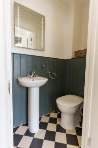 a bathroom with a sink and a toilet and a mirror at Bower House in London