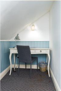 Cette chambre mansardée comprend un bureau et une chaise. dans l'établissement Bower House, à Londres